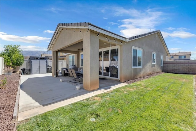 1511 Asteroid Way, Beaumont, CA 92223 - rear view of house with stucco siding, a fenced backyard, a gate, ceiling fan, and a patio