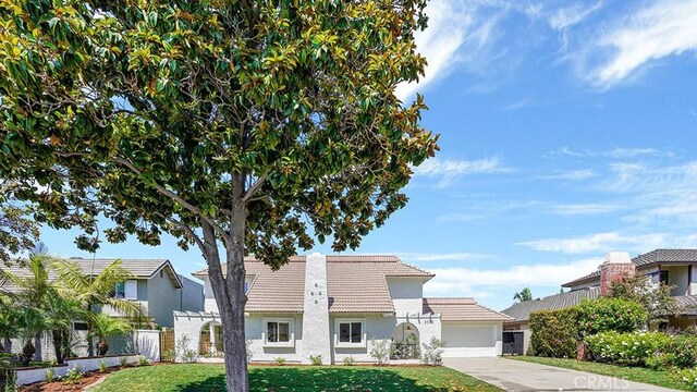 3073 N Pinewood St, Orange, CA 92865 - view of front of house featuring a tiled roof, driveway, an attached garage, and stucco siding