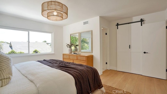 3073 N Pinewood St, Orange, CA 92865 - bedroom with a barn door, light wood finished floors, and a closet