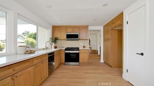 3073 N Pinewood St, Orange, CA 92865 - kitchen with stainless steel appliances, light wood-type flooring, light countertops, and tasteful backsplash