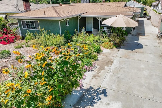 18934 San Bernardino Ave, Bloomington, CA 92316 - view of side of property featuring a chimney, stucco siding, covered porch, and a shingled roof