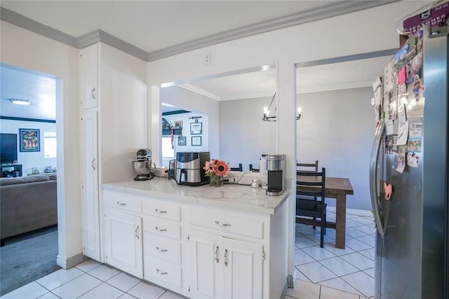 18934 San Bernardino Ave, Bloomington, CA 92316 - kitchen with freestanding refrigerator, light tile patterned flooring, crown molding, white cabinetry, and light stone countertops