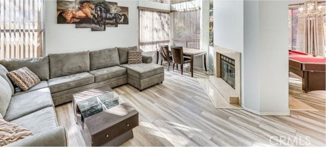 1020 La Salle Cir, Corona, CA 92879 - living area with healthy amount of natural light, wood finished floors, a chandelier, and a high end fireplace