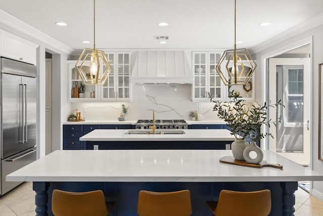 6257 Alverton, Carlsbad, CA 92009 - kitchen with stainless steel built in fridge, custom exhaust hood, a kitchen island with sink, crown molding, and light countertops