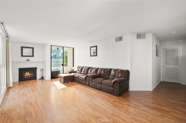 911 N Kings Rd Unit 310, West Hollywood, CA 90069 - living room with light wood-style flooring and a lit fireplace