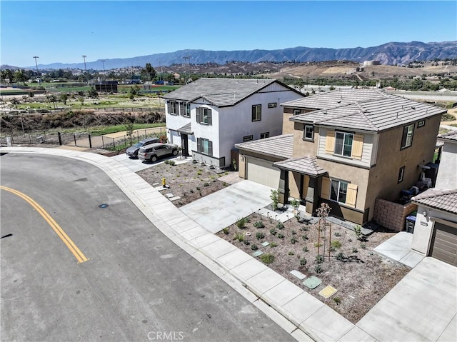 19465 Brush Creek Way, Lake Elsinore, CA 92532 - view of front of property with concrete driveway, stucco siding, a mountain view, a garage, and a tiled roof
