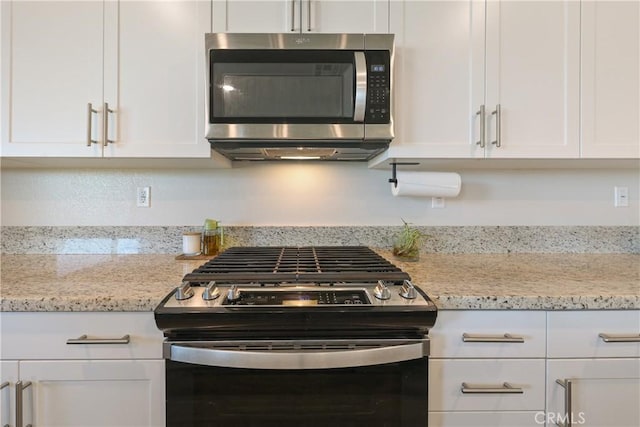 19465 Brush Creek Way, Lake Elsinore, CA 92532 - kitchen featuring range with gas stovetop, stainless steel microwave, white cabinetry, and light stone countertops