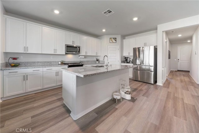 19465 Brush Creek Way, Lake Elsinore, CA 92532 - kitchen featuring appliances with stainless steel finishes, white cabinets, light wood finished floors, a center island with sink, and recessed lighting