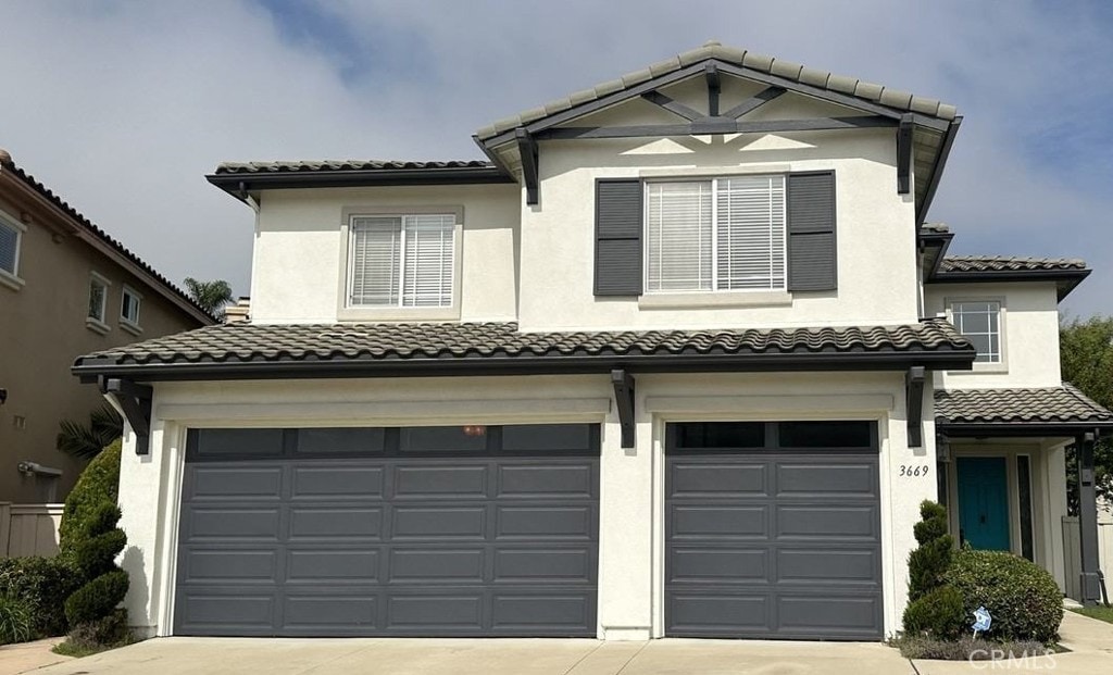 3669 Strata Dr, Carlsbad, CA 92010 - view of front facade with a tile roof, concrete driveway, a garage, and stucco siding