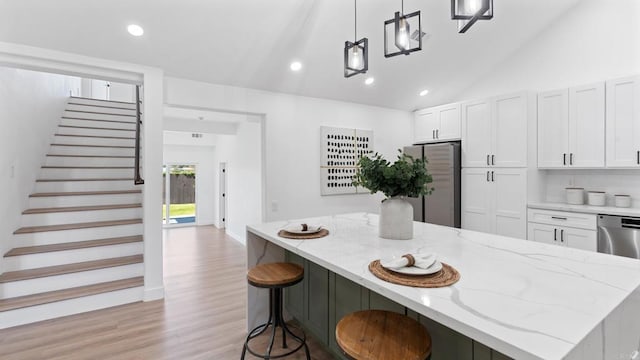 5122 Coban St, San Diego, CA 92114 - kitchen with stainless steel appliances, white cabinets, lofted ceiling, a kitchen island, and light wood-style floors