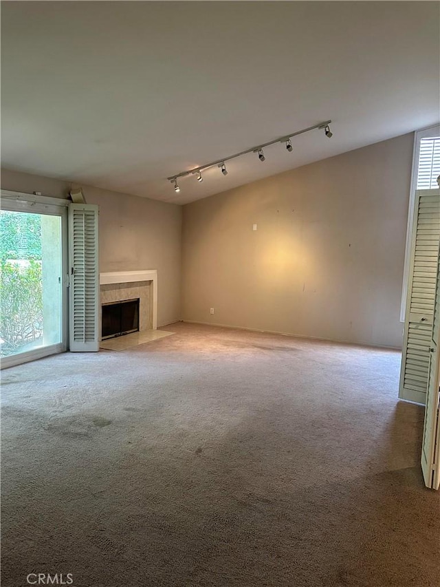 23135 Park Contessa, Calabasas, CA 91302 - unfurnished living room with rail lighting, carpet, and a tiled fireplace
