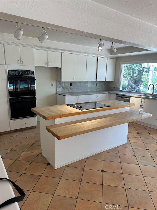 23135 Park Contessa, Calabasas, CA 91302 - kitchen with butcher block counters, black appliances, white cabinetry, decorative backsplash, and light tile patterned floors