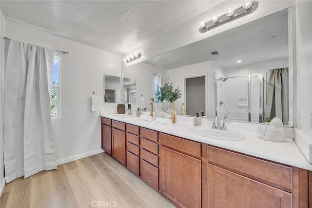 9370 Bistro Pl, Rancho Cucamonga, CA 91730 - full bathroom with a shower stall, plenty of natural light, double vanity, and wood finished floors