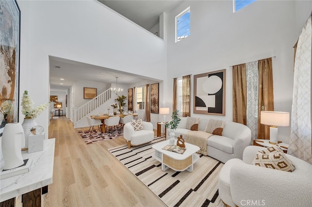 9370 Bistro Pl, Rancho Cucamonga, CA 91730 - living room featuring stairs, a chandelier, wood finished floors, plenty of natural light, and a high ceiling