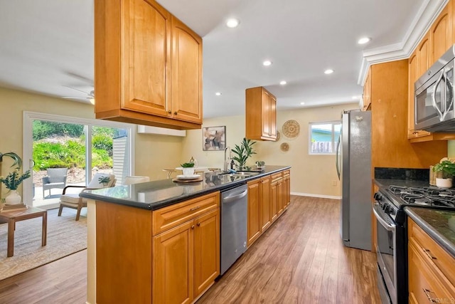 4110 Lewis St, Oceanside, CA 92056 - kitchen featuring appliances with stainless steel finishes, light wood finished floors, ceiling fan, recessed lighting, and dark stone counters