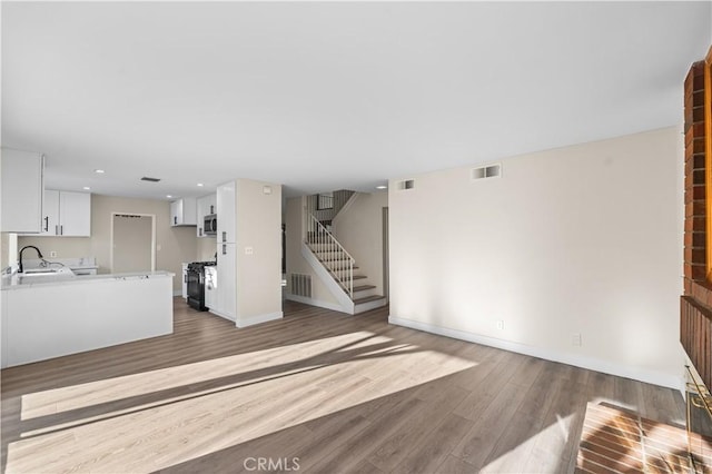 36647 Apache Plume Dr, Palmdale, CA 93550 - unfurnished living room with stairway, wood finished floors, and recessed lighting