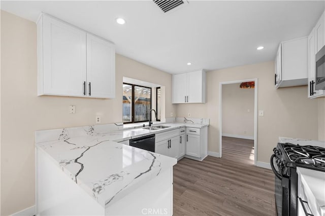 36647 Apache Plume Dr, Palmdale, CA 93550 - kitchen with black appliances, a peninsula, light stone counters, wood finished floors, and white cabinets