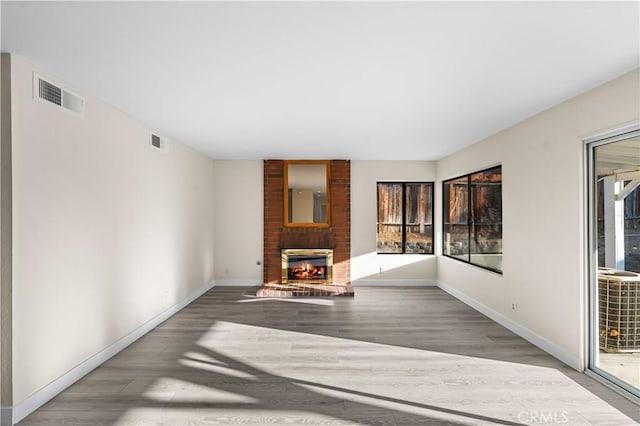 36647 Apache Plume Dr, Palmdale, CA 93550 - unfurnished living room with wood finished floors, a fireplace, and healthy amount of natural light