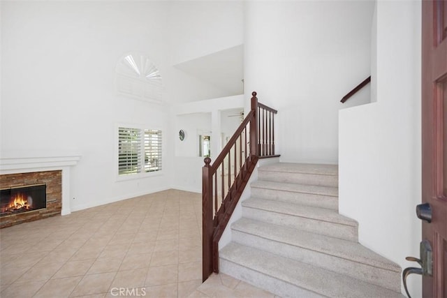 15 Havre Ct, Lake Forest, CA 92610 - staircase featuring a towering ceiling, a glass covered fireplace, and tile patterned floors