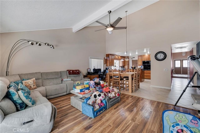 13329 Mission Tierra Way, Granada Hills, CA 91344 - living room featuring a ceiling fan, beamed ceiling, light wood-style floors, a textured ceiling, and high vaulted ceiling