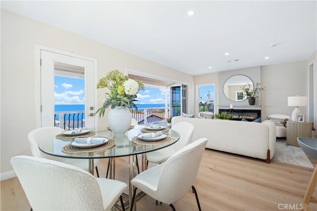 2961 Rounsevel, Laguna Beach, CA 92651 - dining area with light wood-style flooring, a glass covered fireplace, and recessed lighting