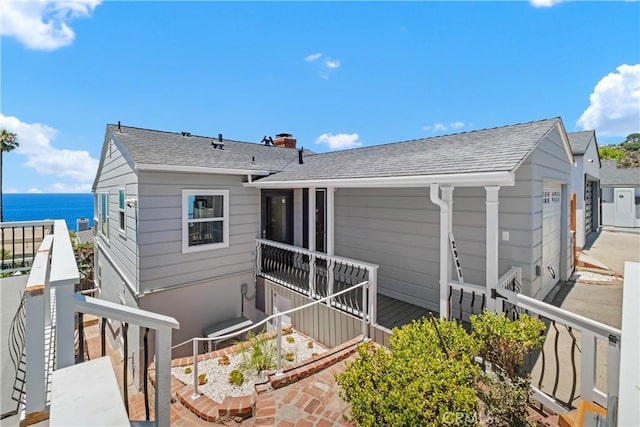 2961 Rounsevel, Laguna Beach, CA 92651 - rear view of house featuring a chimney, a water view, and a shingled roof