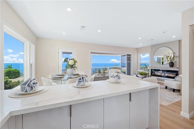 2961 Rounsevel, Laguna Beach, CA 92651 - kitchen featuring light wood-type flooring, plenty of natural light, recessed lighting, a glass covered fireplace, and open floor plan