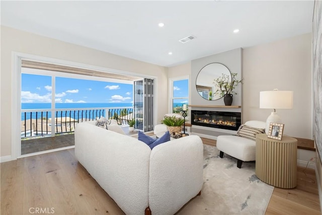 2961 Rounsevel, Laguna Beach, CA 92651 - living room featuring light wood-type flooring, a glass covered fireplace, recessed lighting, and a water view