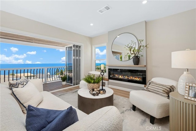 2961 Rounsevel, Laguna Beach, CA 92651 - living area featuring wood finished floors, a water view, a glass covered fireplace, and recessed lighting