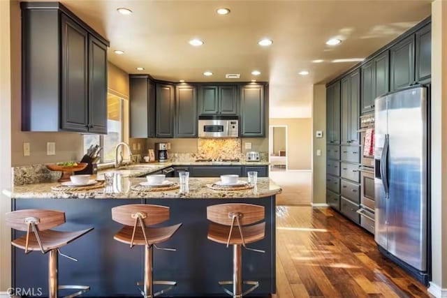 8075 Quail Trl, Yucca Valley, CA 92284 - kitchen featuring stainless steel fridge, a peninsula, dark wood finished floors, recessed lighting, and light stone counters