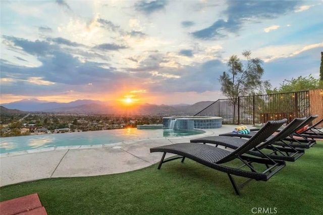 8075 Quail Trl, Yucca Valley, CA 92284 - pool at dusk with a patio, an outdoor pool, a lawn, and a mountain view