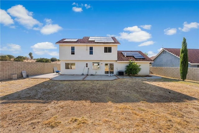 37338 Salem Ct, Palmdale, CA 93550 - back of house featuring roof mounted solar panels, a patio area, a fenced backyard, stucco siding, and a tile roof