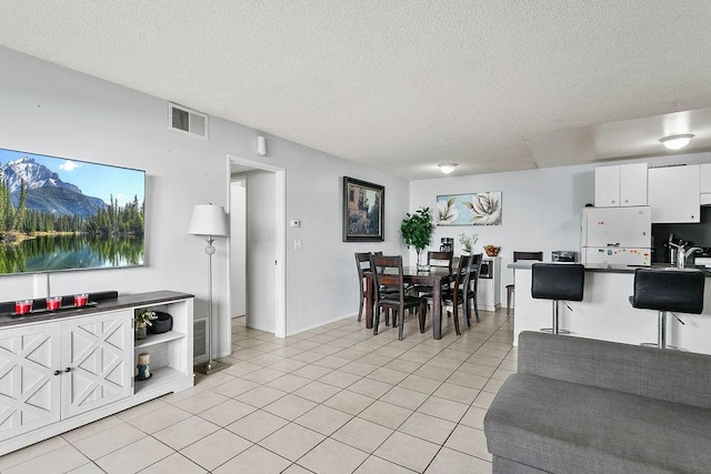 2521 W Sunflower Ave Unit R1, Santa Ana, CA 92704 - living room featuring a textured ceiling and light tile patterned floors