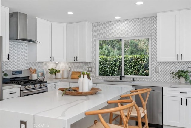 32772 Shipside Dr, Dana Point, CA 92629 - kitchen with stainless steel appliances, wall chimney exhaust hood, a kitchen breakfast bar, light stone countertops, and white cabinetry