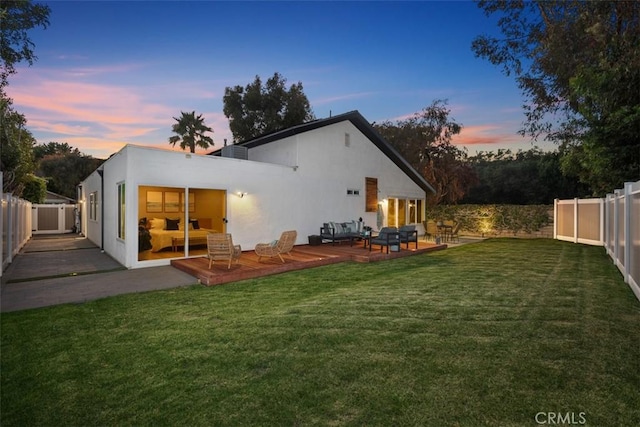 32772 Shipside Dr, Dana Point, CA 92629 - back of house at dusk featuring outdoor lounge area, a fenced backyard, a wooden deck, and stucco siding