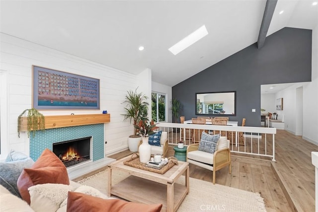 32772 Shipside Dr, Dana Point, CA 92629 - living area with light wood-type flooring, high vaulted ceiling, a tiled fireplace, beamed ceiling, and a skylight