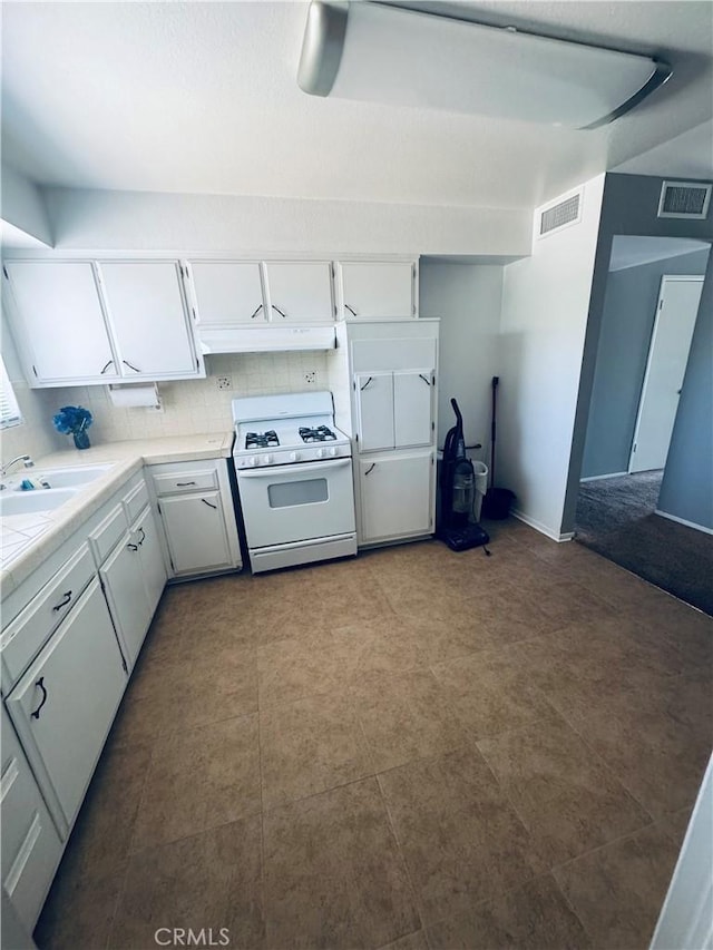 27102 Capilano Dr, Menifee, CA 92586 - kitchen with white gas range, under cabinet range hood, white cabinetry, and tile countertops