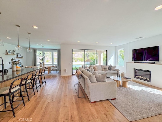 28524 Songbird Way, Saugus, CA 91350 - living room featuring light wood-type flooring, a glass covered fireplace, and recessed lighting