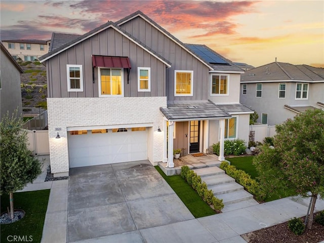 28524 Songbird Way, Saugus, CA 91350 - view of front of property featuring board and batten siding, a garage, concrete driveway, solar panels, and brick siding