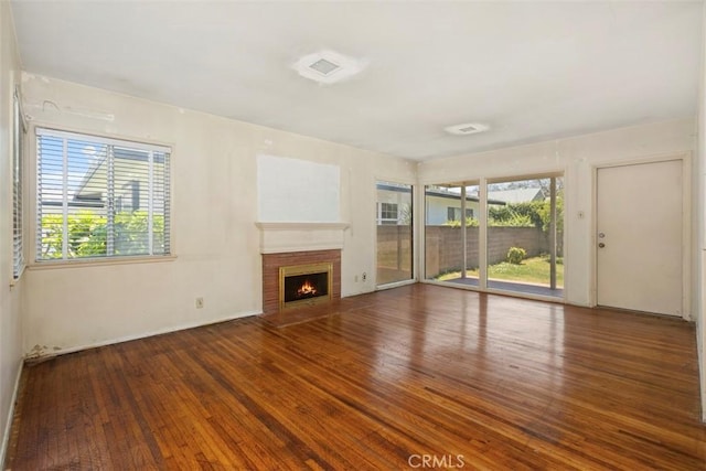 2729 N Studebaker Rd, Long Beach, CA 90815 - unfurnished living room with hardwood / wood-style floors, a brick fireplace, and healthy amount of natural light