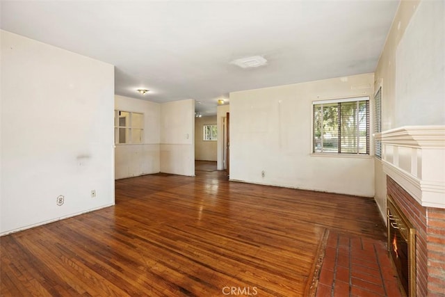 2729 N Studebaker Rd, Long Beach, CA 90815 - empty room with healthy amount of natural light, wood finished floors, and a brick fireplace