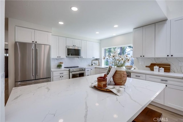 14632 Kimberly Cir, Tustin, CA 92780 - kitchen with appliances with stainless steel finishes, tasteful backsplash, white cabinets, light stone counters, and recessed lighting