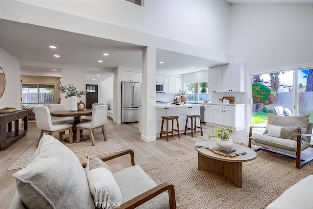 14632 Kimberly Cir, Tustin, CA 92780 - living room featuring light wood finished floors, recessed lighting, and a towering ceiling