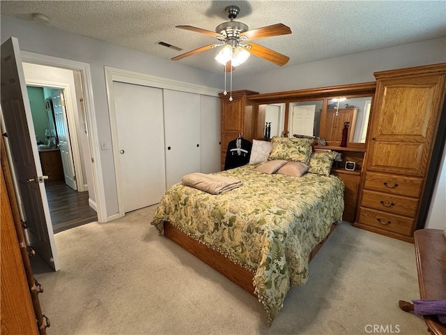 512 E Clinton Ave, Atwater, CA 95301 - bedroom with light colored carpet, a closet, a textured ceiling, and a ceiling fan
