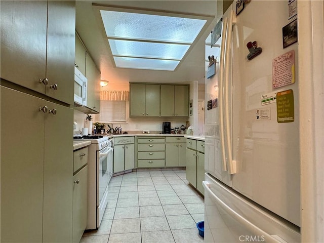 512 E Clinton Ave, Atwater, CA 95301 - kitchen with white appliances, green cabinetry, light countertops, light tile patterned flooring, and a skylight