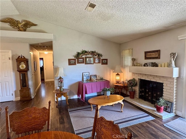 512 E Clinton Ave, Atwater, CA 95301 - living room featuring vaulted ceiling, wood finished floors, a fireplace, and a textured ceiling