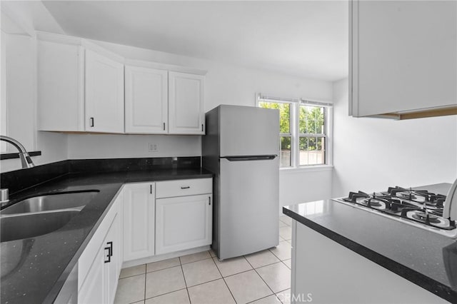 18656 Runnymede St, Reseda, CA 91335 - kitchen with freestanding refrigerator, white cabinetry, light tile patterned floors, gas stovetop, and dark stone countertops