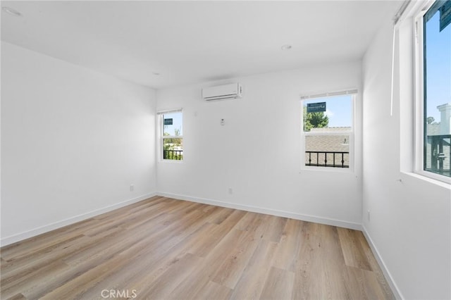 18656 Runnymede St, Reseda, CA 91335 - empty room featuring a wall unit AC, healthy amount of natural light, and light wood finished floors