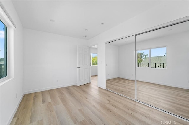 18656 Runnymede St, Reseda, CA 91335 - unfurnished bedroom with multiple windows, light wood-style flooring, and a closet