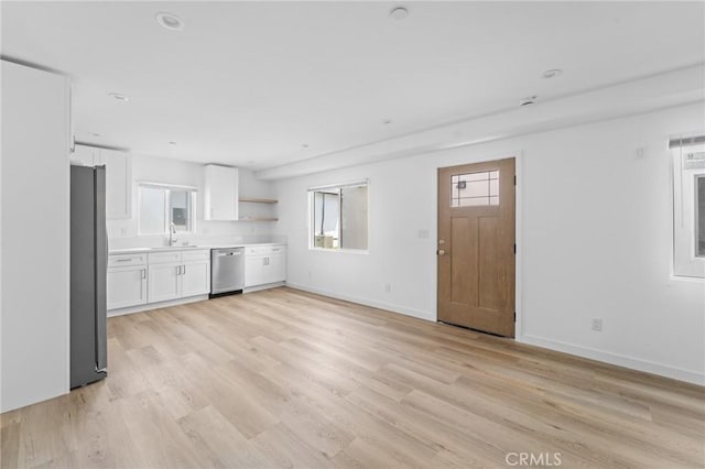 18656 Runnymede St, Reseda, CA 91335 - kitchen with appliances with stainless steel finishes, white cabinetry, light wood-type flooring, and plenty of natural light
